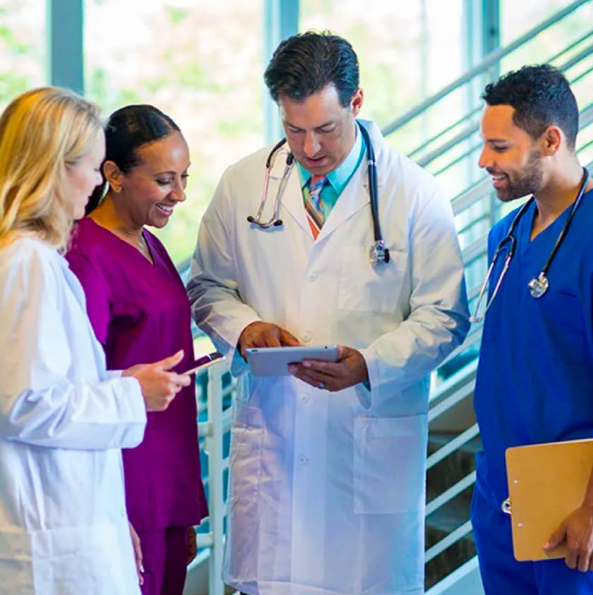two doctors and two nurses looking at paperwork