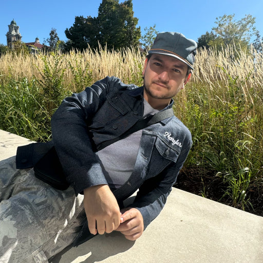 Man wearing Silver Denim Jacket while sitting outside 