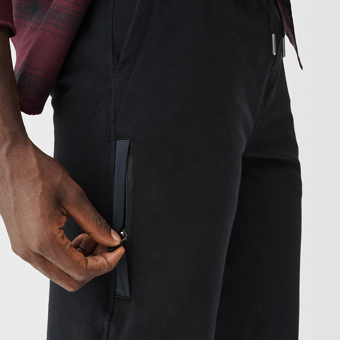 profile of a man zipping the side pocket of his pants