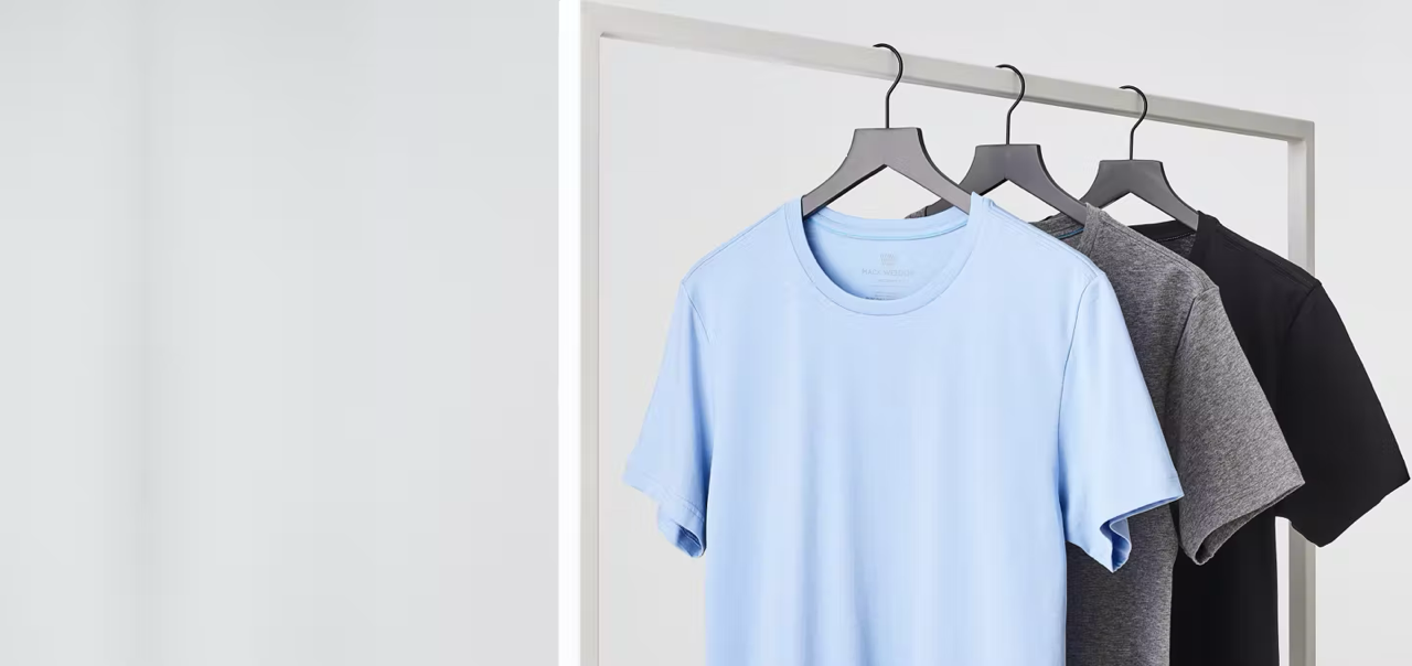 image of a baby blue, grey, and black crew neck t-shirts on hangers 