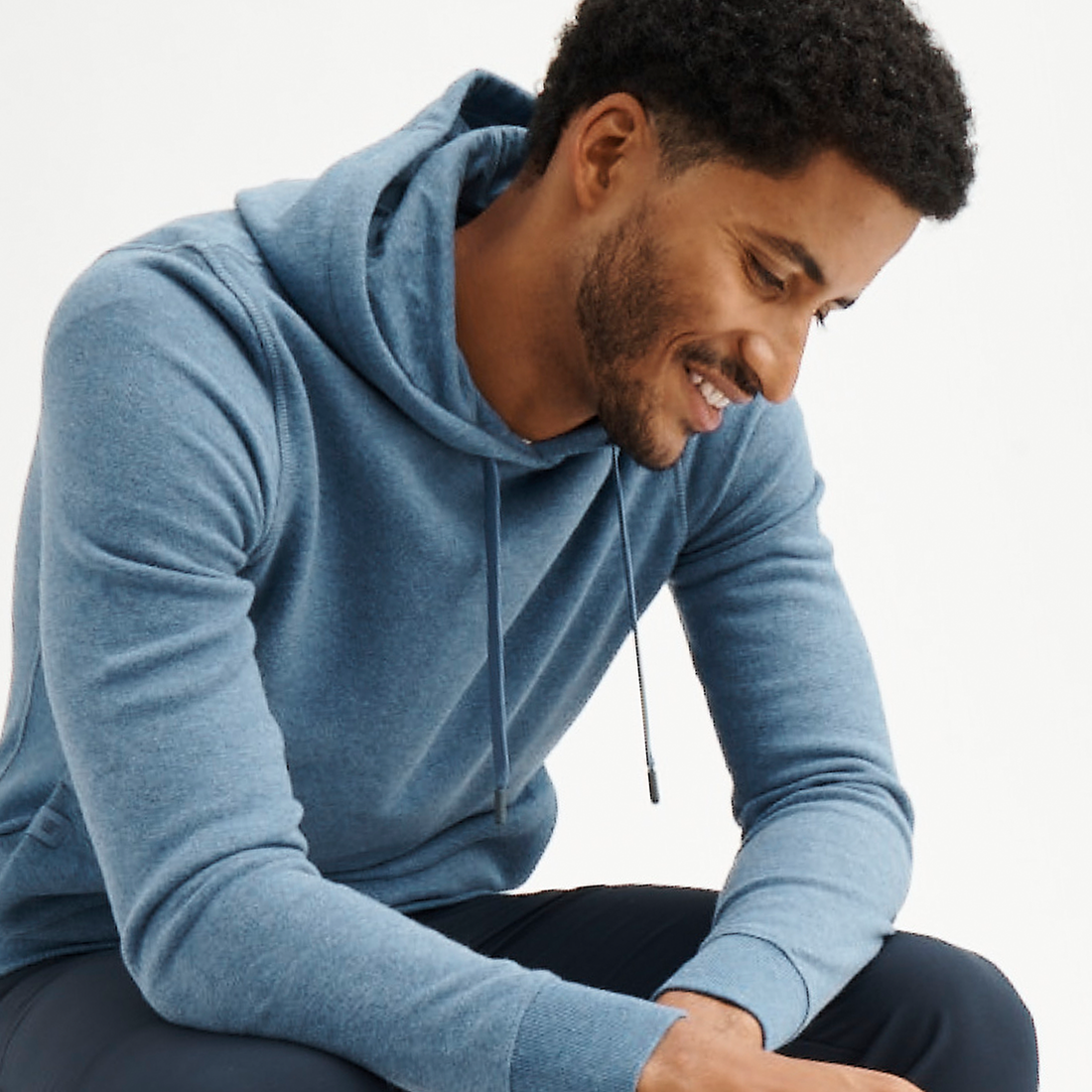 man in blue hoodie smiles
