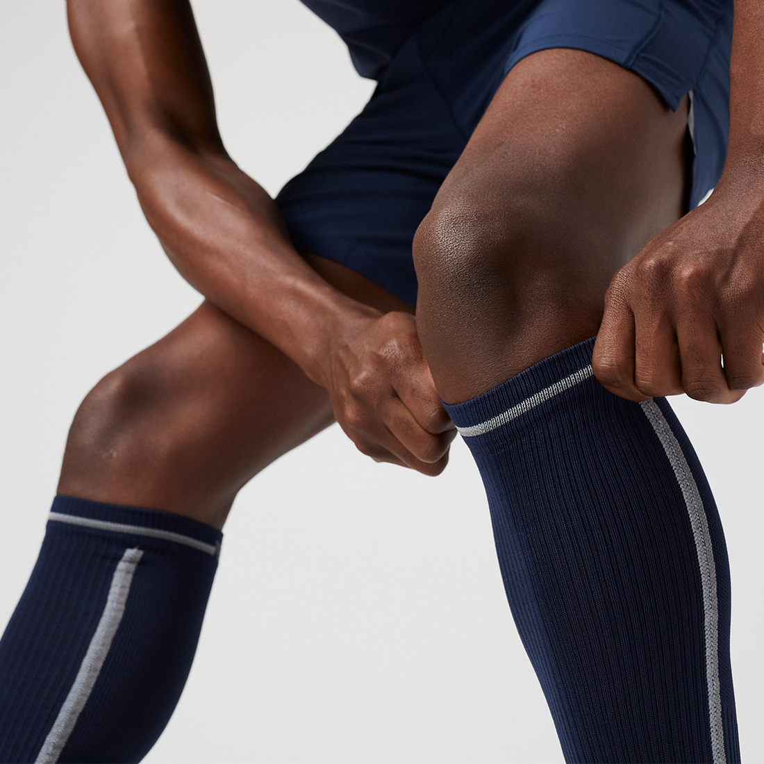 image of a man's legs as he pulls up knee high socks