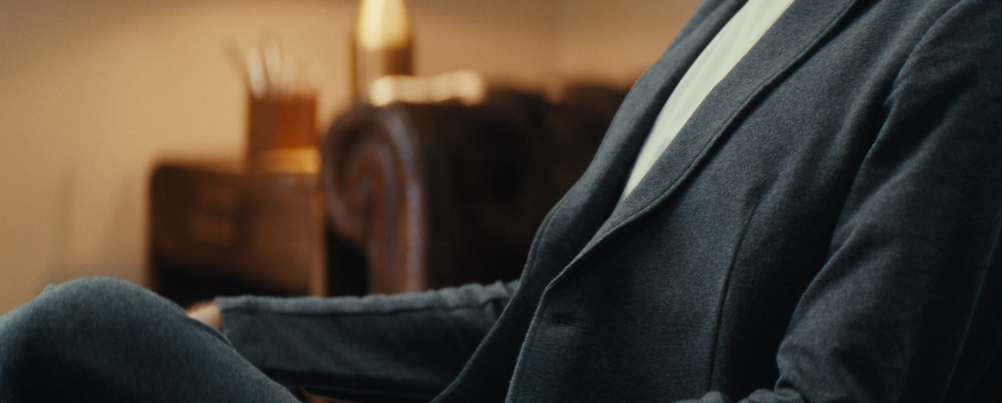 Close up of a man sitting in a chair wearing a comfortable looking blazer